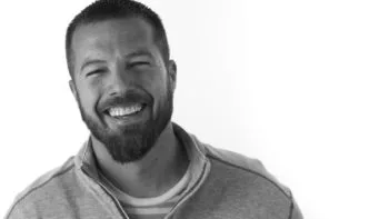 Adam Madden, smiling, in a black and white portrait